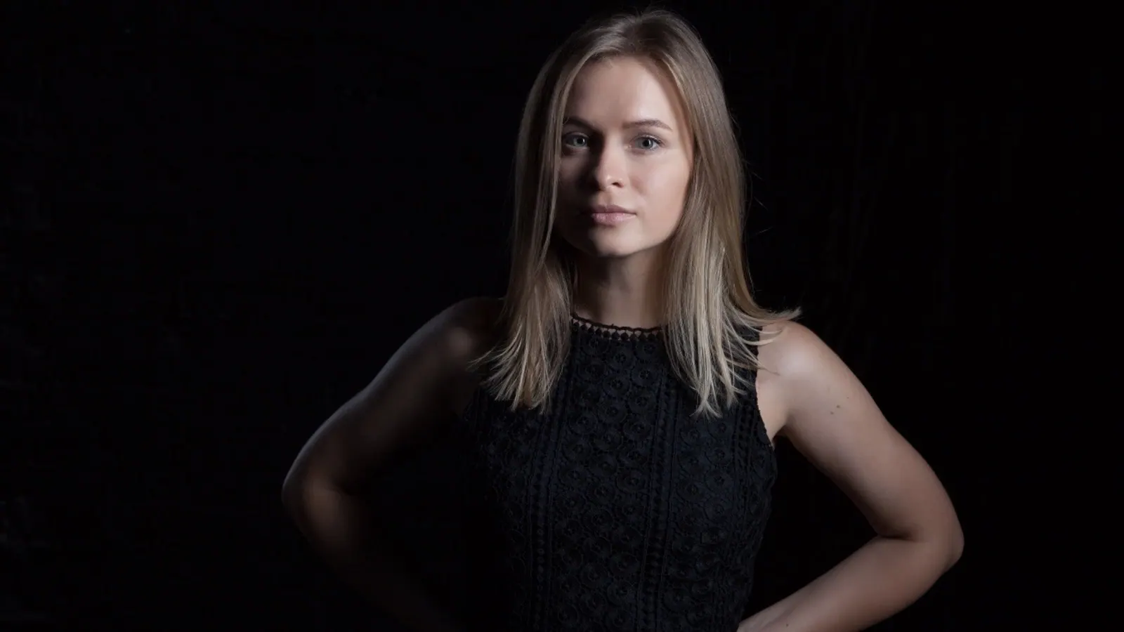 Krystyna in low-key studio light, hand on hip
